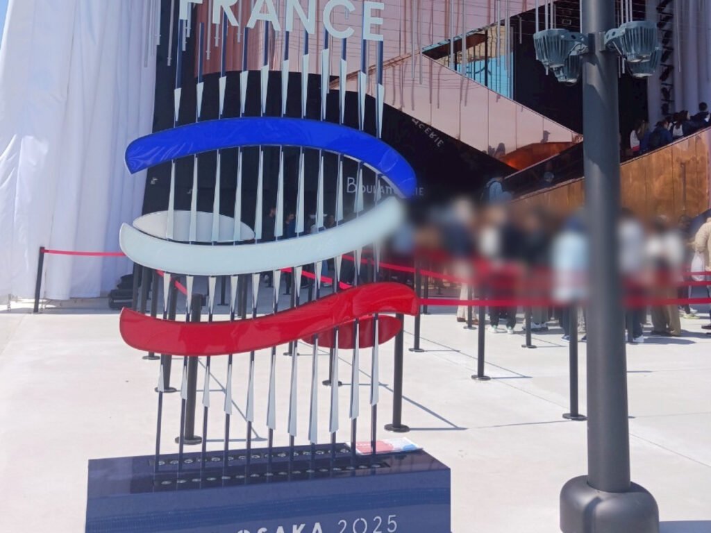 Entrance to the France Pavilion with tricolor sculpture and crowd of visitors