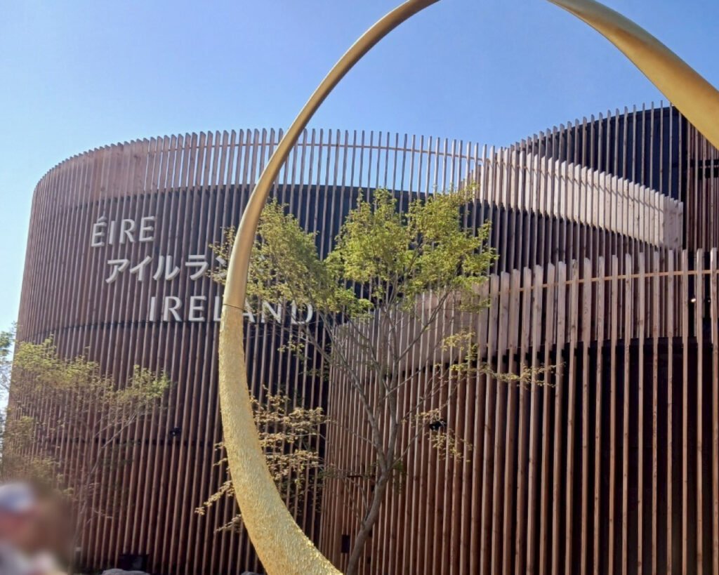 Exterior of the Ireland Pavilion at Expo 2025 Osaka with wood slats and a crescent structure